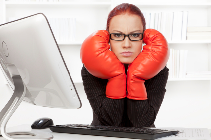 Agressive businesswoman with boxing gloves ready for fighting